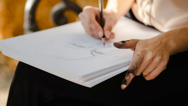 한 사람이 종이에 신중하게 무언가를 적고 있는 모습